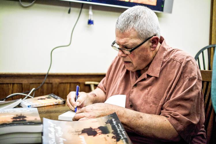 Local Author Norman Schell signs books for patrons after a rousing reading.